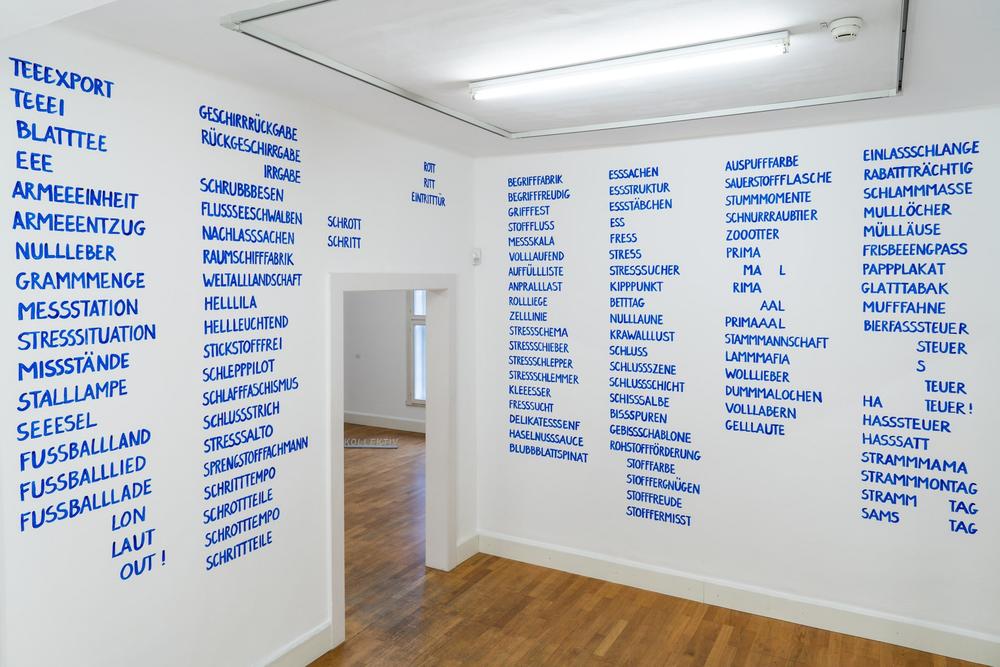 Ausstellungsansicht, Wortlisten auf den Wänden in blauen, versalen Textspalten